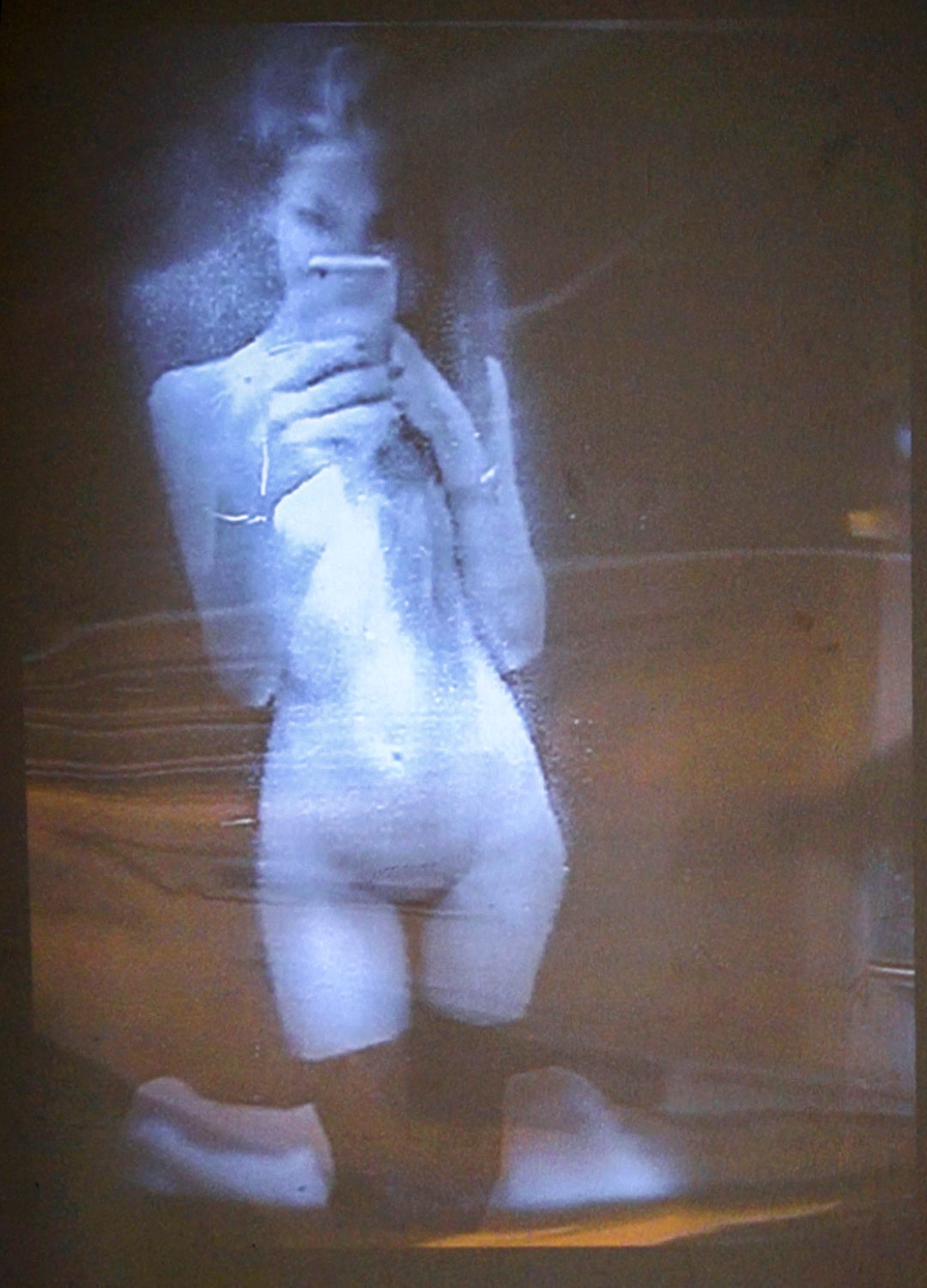 Autopoiesis | Was vom Kino übrig bleibt | What Remains Of Cinema. #2 André Werner, interactive video installation, 2018 Closed circuit depicting a nude girl making a selfie in the mirror of a changing cubicle.